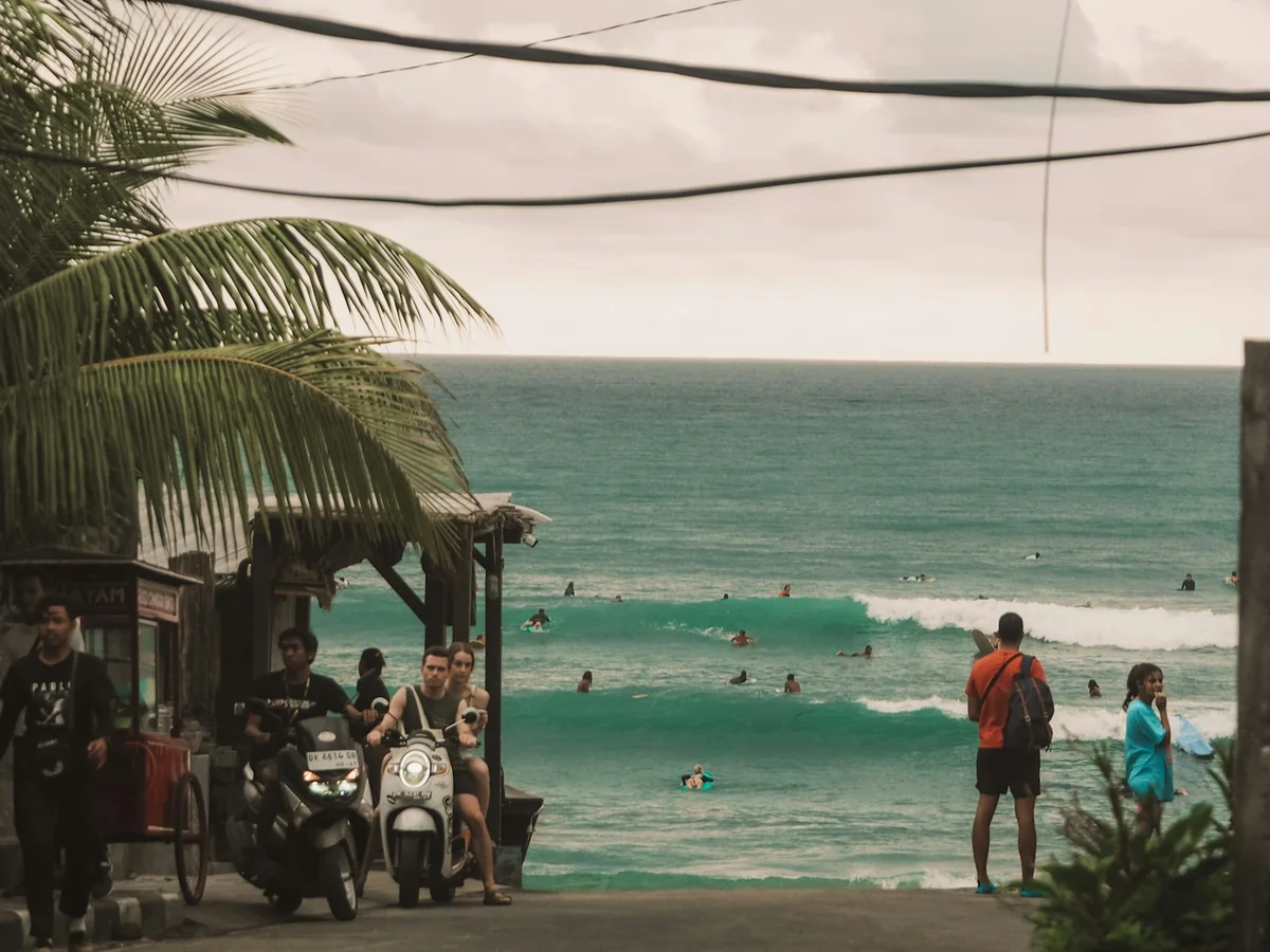 People walking along a beach at the end of the day