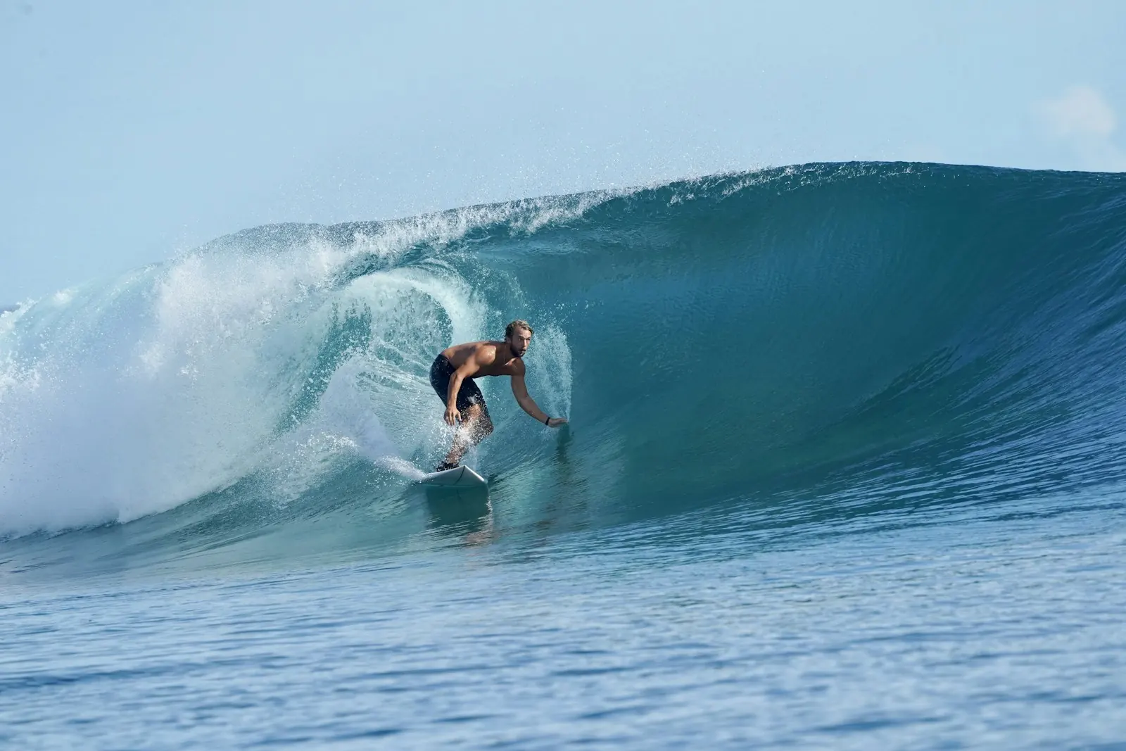 Surfer riding a wave at a Mentawai Islands surf spot